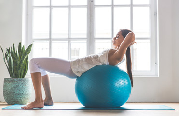 Beautiful girl making training and yoga at home in the morning