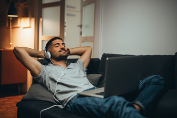 man relaxing in his apartment listening to a music