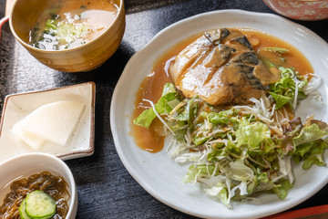 Japanese cuisine, grilled Saba or mackerel fish topped with sauce served with Miso soup and salad