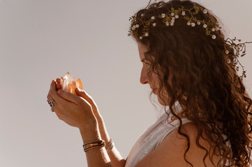Innocent Young Woman holding crystals. White background. 