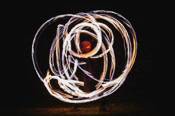 Fire spinner making different figures with fire. Slow motion image