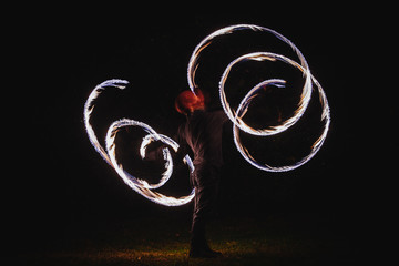 Fire spinner making different figures with fire. Slow motion image