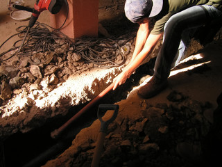 Obraz premium A man works with a pickaxe. Manual labor. Construction. Venezuela.