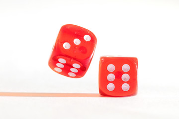 Two red dice, one moving, one static on white background