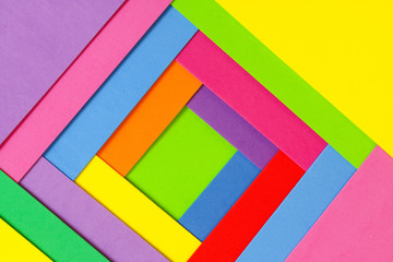 An abstract geometric textured background of multicolored rainbow colors created with overlapping foam craft paper 