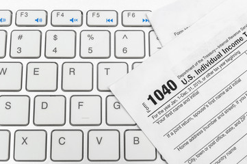 Tax forms on the computer keyboard.