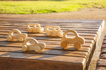 Wooden toy cars on wooden table.     並んだオモチャの車