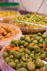 Homemade pickled green olives with garlic and spices on spanish market