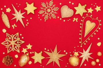 Fototapeta na wymiar Christmas background border with gold tree bauble decorations on red background with copy space. Traditional Christmas card for the festive season.