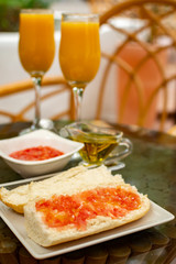 Traditional andalusian breakfast with freshly squeezed orange juice, bread toasts, fresh ground tomatoes and olive oil