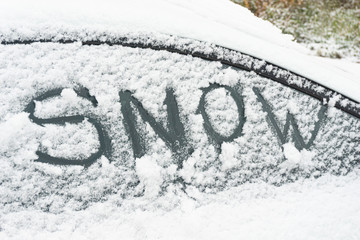 Snow-covered car windshield. parked car covered with snow during snowing in winter time.