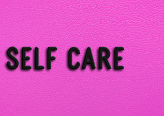 “Self care” on pink leather background