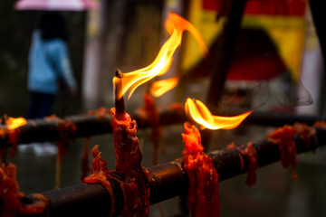 Burning red candles in a taoist temple. Shallow depth of field.