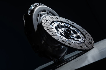 Close-up picture of a part of car, black clutch disk isolated on black background - obrazy, fototapety, plakaty