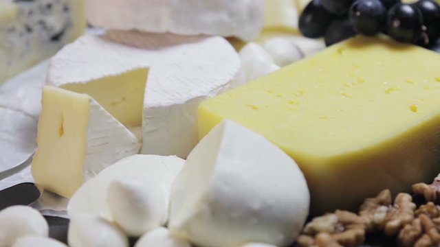 assorted different types of cheeses with fruits, nuts, dried fruits on the table