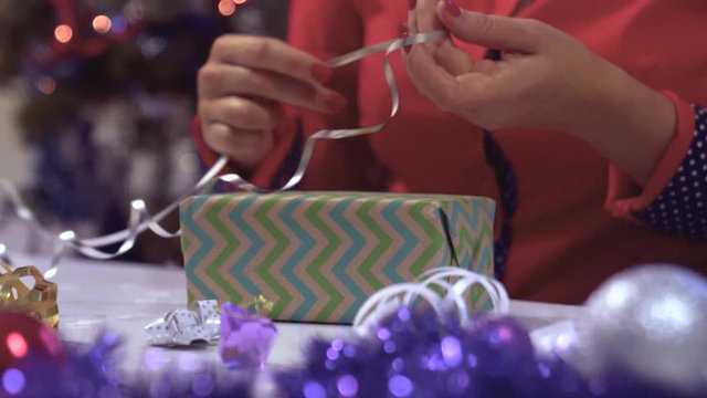 Slow motion Christmas handmade gift as a woman hands wrapping present.