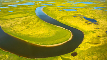 Landscape of the arctic tundra in summer. Rivers, lakes, northern vegetation. View from above. The...