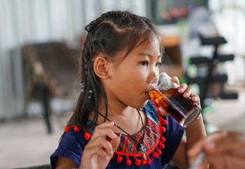 Young girl is drinking soft drink.
