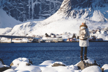 girl walks along the shore of the fjord