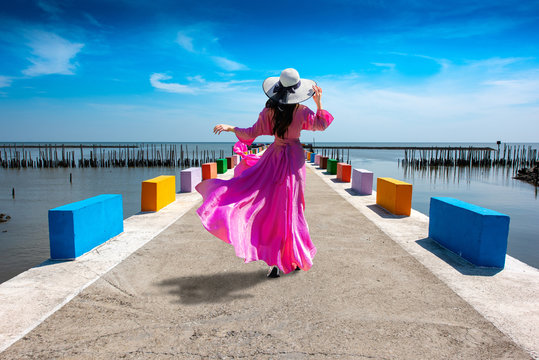 Asian women wearing purple dresses are standing on the bridge at Rainbow Bridge, Kalong village, Samut Sakhon province, Thailand.