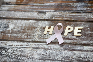 Pink ribbon. Symbol of breast cancer awareness. Health care conception. Preventive measures. October checking time. Women health. Decorative wood background.
