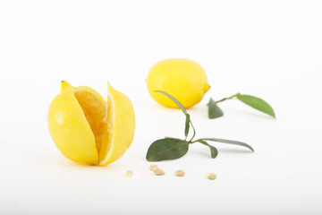 Fresh lemons with leaves isolated on white background.Two ripe, juicy lemons, one cut.