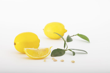 Fresh lemons with leaves isolated on white background.Two ripe, juicy lemons with slice of lemon.