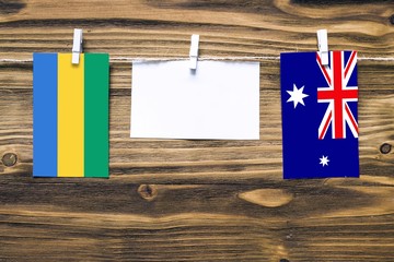 Hanging flags of Gabon and Heard and Mcdonald Islands attached to rope with clothes pins with copy...