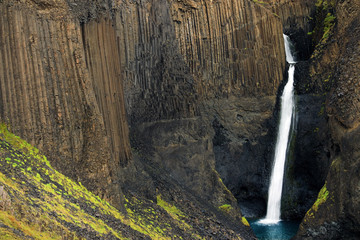 Hengifoss Canyon with the Hengifoss Waterfall, the third highest waterfall in Iceland is surrounded...