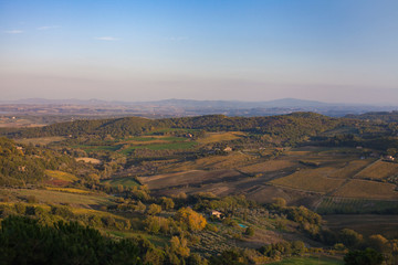 View from the top of mountain in Italy overlooking a Italian valley rolling hills blue skies 