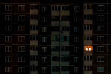 light in a single window. Flat night panorama of multicolor light in windows of multistory...