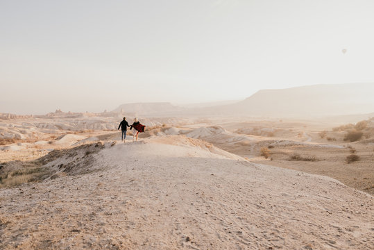 Two person standing on brown and white soil
