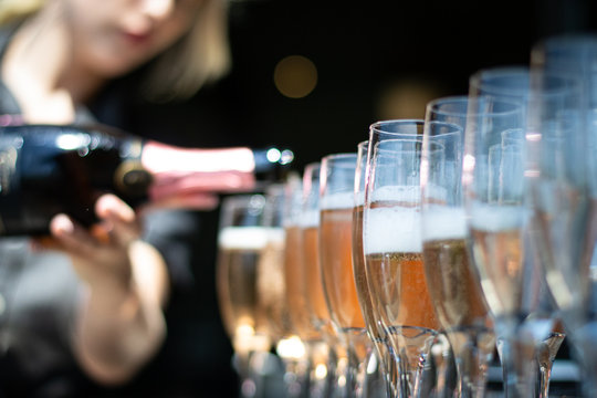 Woman Pouring Champagne Into Glasses