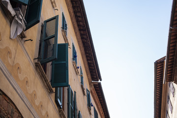 Obraz premium View looking up at widow shutters opened and closed in narrow streets of small town Italy