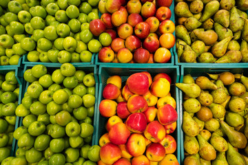 Fruits market flatlay. Many green and red apples and pears in containers elevated view. vegetable texture
