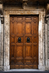 Old , vintage wooden doors with lions head knockers and stone facade