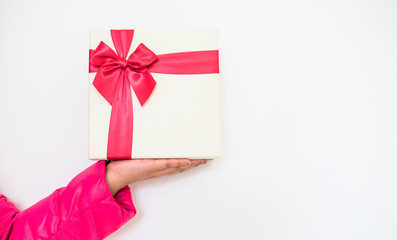Woman hands holding Gift box with red bow on white background.Concept for delivery gift on holidays...