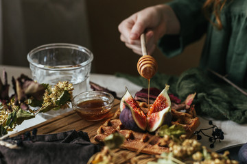 On Belgian waffles decorated with figs, dripping honey