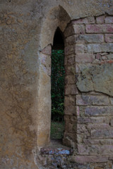 Fototapeta na wymiar Old stone wall and ornate window of castle entrance