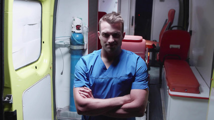 Naklejka premium Happy corpsman stand on the background of ambulance car.