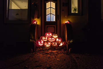 Night shot of illuminated pumpkins in front of a house