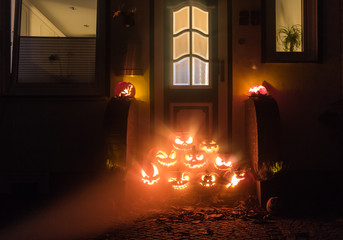 Night shot of illuminated pumpkins in front of a house