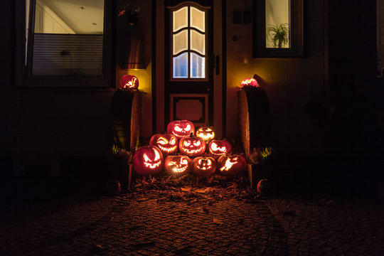 Night shot of illuminated pumpkins in front of a house