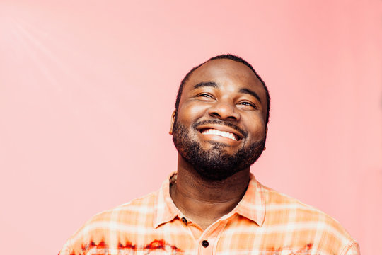 Portrait of a young man with big smile looking up, isolated on colorful background