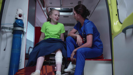 Naklejka premium Nurse and sick girl in ambulance car.