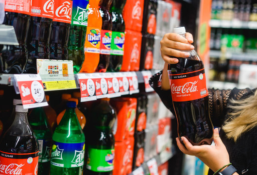 Bangkok, Thailand - JUNE 20, 2018: Woman hand choosing Coca cola coke zero cold soft drink or beverage on shelves in supermarket store.