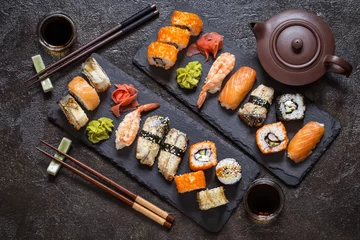 Fototapete Rund sushi rolls with rice and fish, soy sauce on a dark stone background © Наталья Майорова