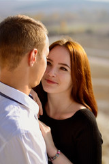 Fototapeta premium Beautiful young girl hugs her man in the woods