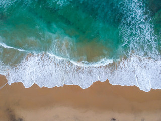 Fototapeta na wymiar Sand beach aerial, top view of a beautiful sandy beach aerial shot with the blue waves rolling into the shore