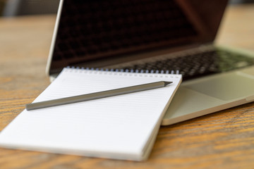 laptop,  notebook and pencil on the table